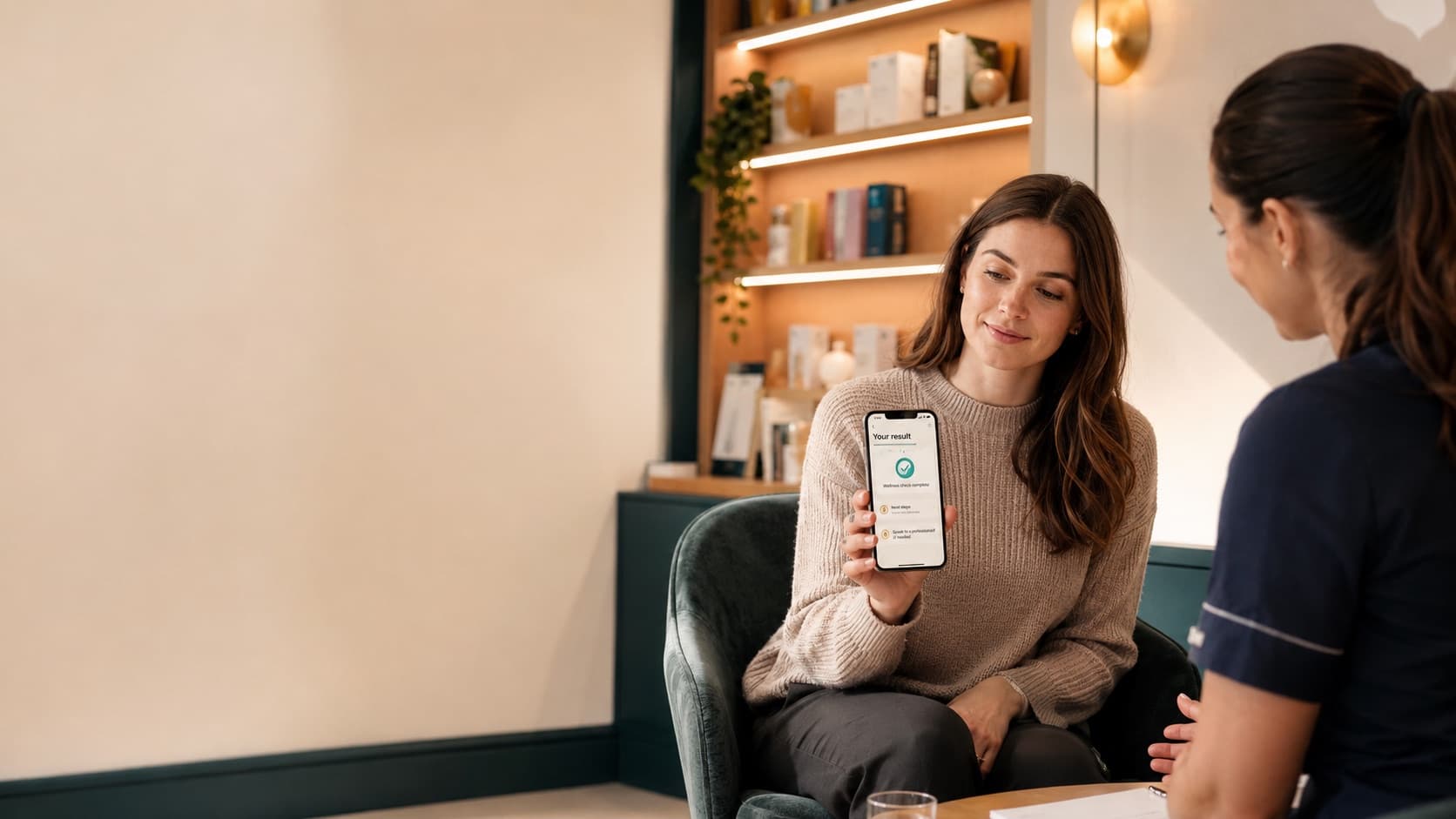 Customer viewing wellness results on a phone while a pharmacy professional explains calmly.